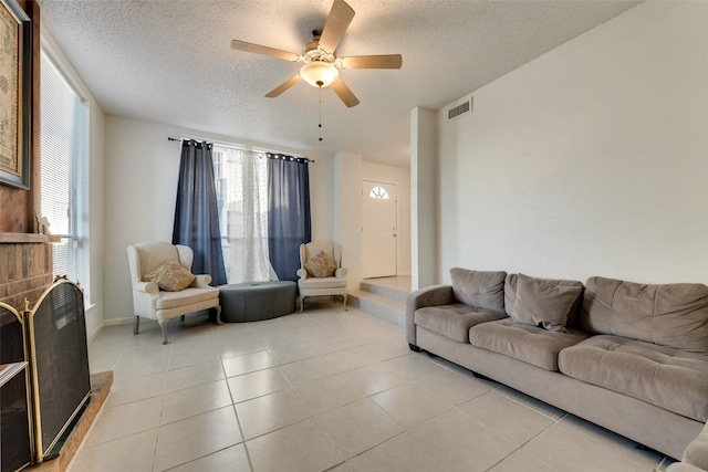 tiled living room with a textured ceiling and ceiling fan