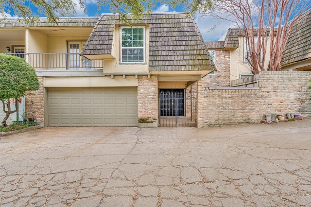 view of front of home featuring a balcony and a garage