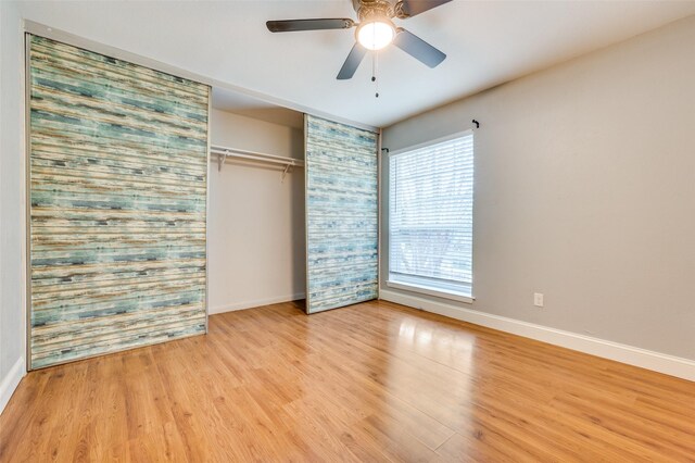 unfurnished bedroom with multiple windows, ceiling fan, a closet, and light hardwood / wood-style floors