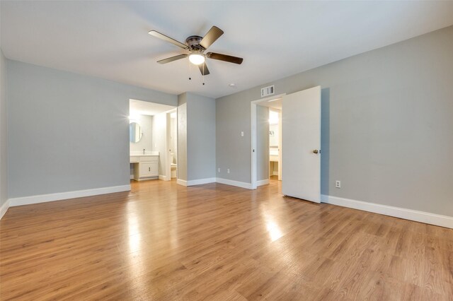 interior space featuring ensuite bathroom, ceiling fan, and light wood-type flooring