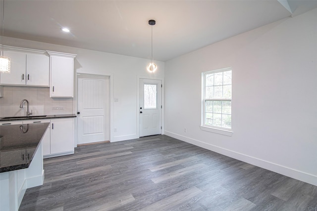 kitchen featuring decorative light fixtures, tasteful backsplash, white cabinetry, sink, and dark hardwood / wood-style flooring