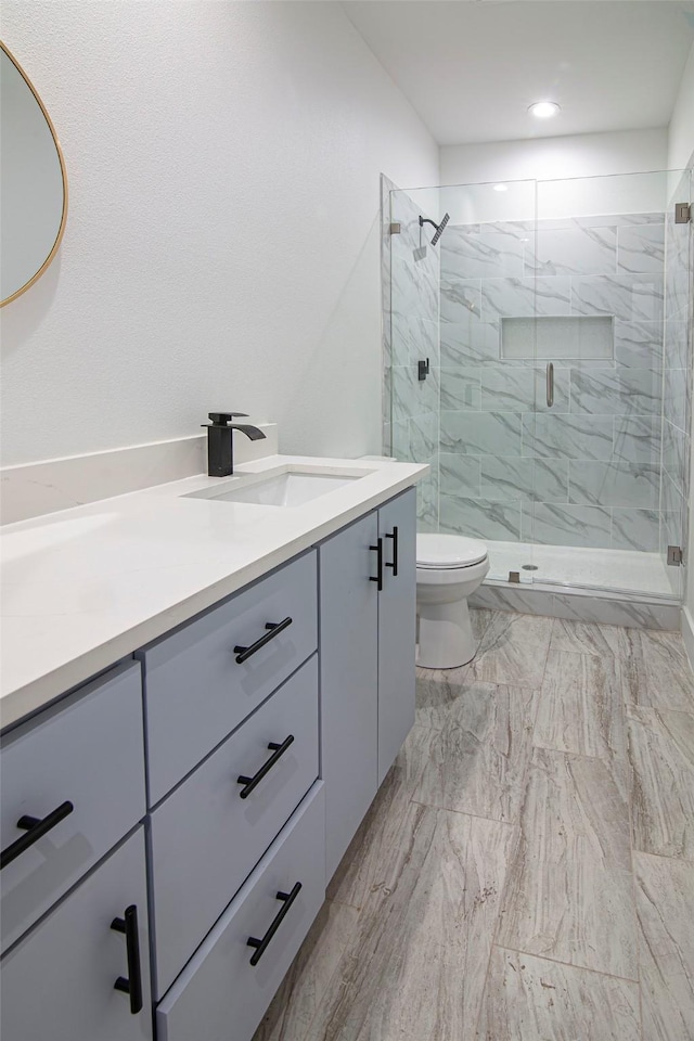 bathroom featuring vanity, walk in shower, and toilet