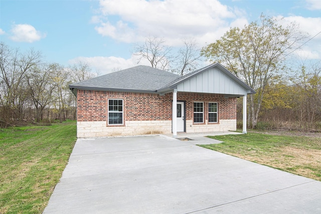 single story home featuring covered porch and a front yard