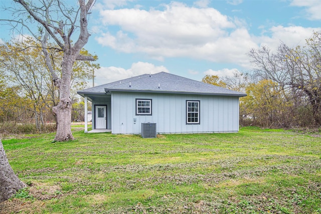 back of house with cooling unit and a yard