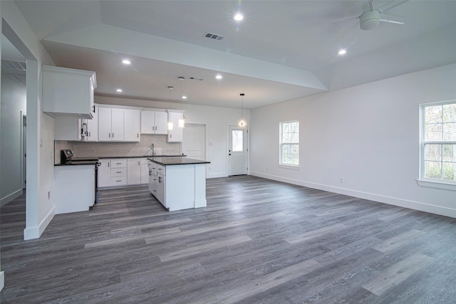 kitchen featuring sink, white cabinetry, decorative light fixtures, a kitchen island, and backsplash