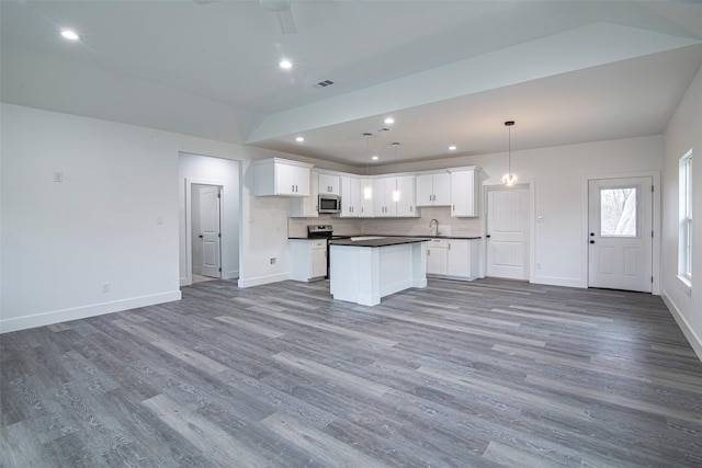 kitchen featuring sink, white cabinetry, a center island, hanging light fixtures, and stainless steel appliances