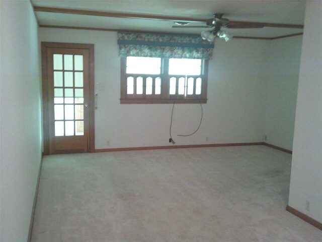 carpeted empty room with ceiling fan and a wealth of natural light