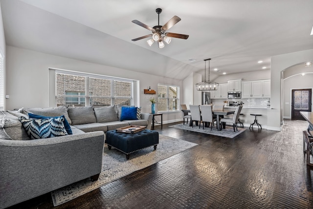 living room featuring dark wood-type flooring, ceiling fan, and vaulted ceiling