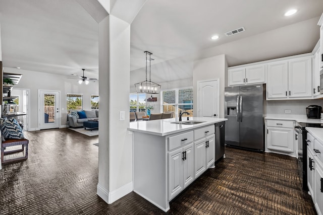 kitchen with sink, hanging light fixtures, a center island with sink, stainless steel appliances, and white cabinets