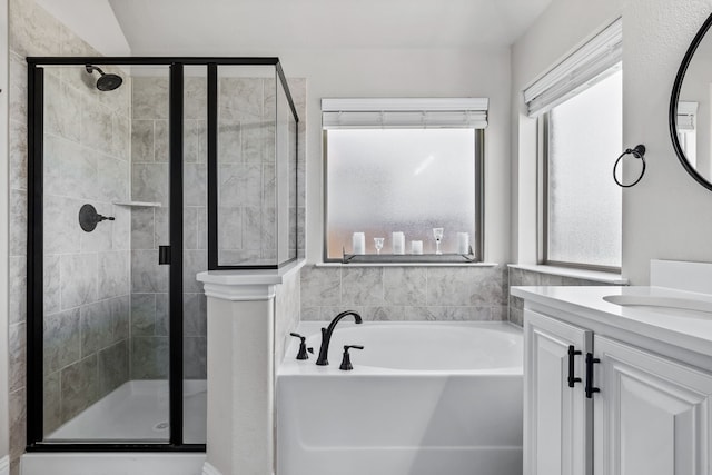 bathroom with vanity, shower with separate bathtub, and a healthy amount of sunlight