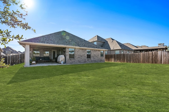 rear view of property featuring a patio area and a lawn