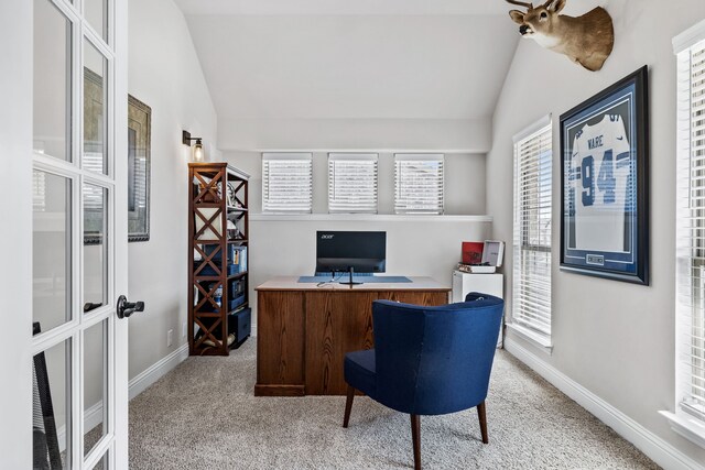 office featuring lofted ceiling, plenty of natural light, and light carpet