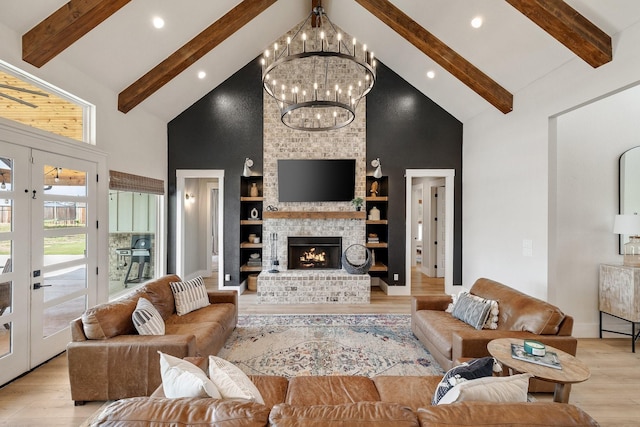 living room featuring built in shelves, a fireplace, high vaulted ceiling, and light hardwood / wood-style floors