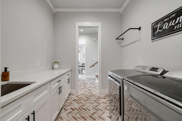 laundry room with washer and clothes dryer, cabinets, and ornamental molding