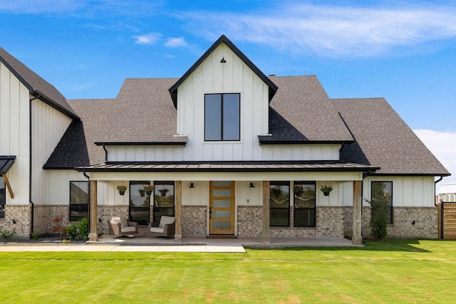 rear view of property with a lawn and an outdoor living space