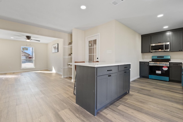 kitchen with ceiling fan, light hardwood / wood-style floors, gray cabinets, and stainless steel appliances