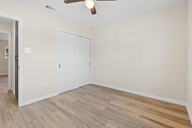 unfurnished bedroom featuring ceiling fan, a closet, and light hardwood / wood-style floors