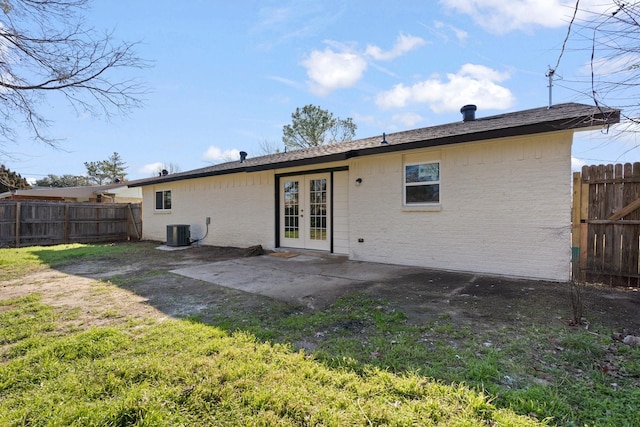 rear view of property with central AC unit, a lawn, a patio area, and french doors