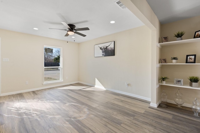 empty room with ceiling fan and hardwood / wood-style flooring