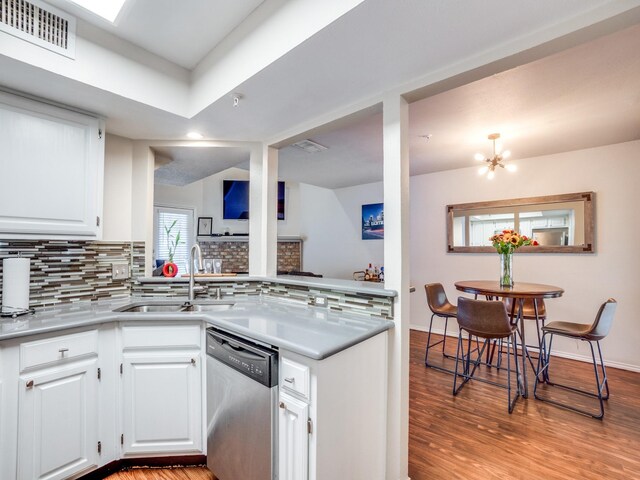 kitchen featuring decorative backsplash, stainless steel dishwasher, sink, light hardwood / wood-style flooring, and white cabinets