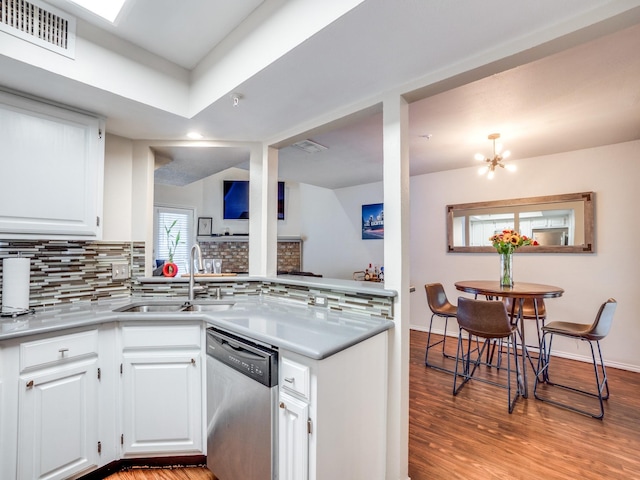 kitchen with white cabinetry, dishwasher, sink, and tasteful backsplash