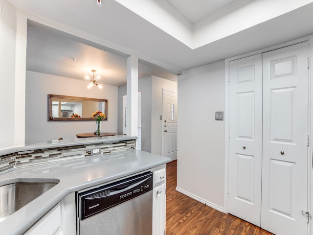 kitchen featuring white cabinetry, dishwasher, dark hardwood / wood-style floors, a notable chandelier, and backsplash