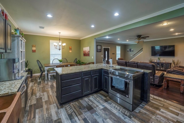 kitchen with ceiling fan with notable chandelier, dark hardwood / wood-style flooring, stainless steel electric range oven, and hanging light fixtures