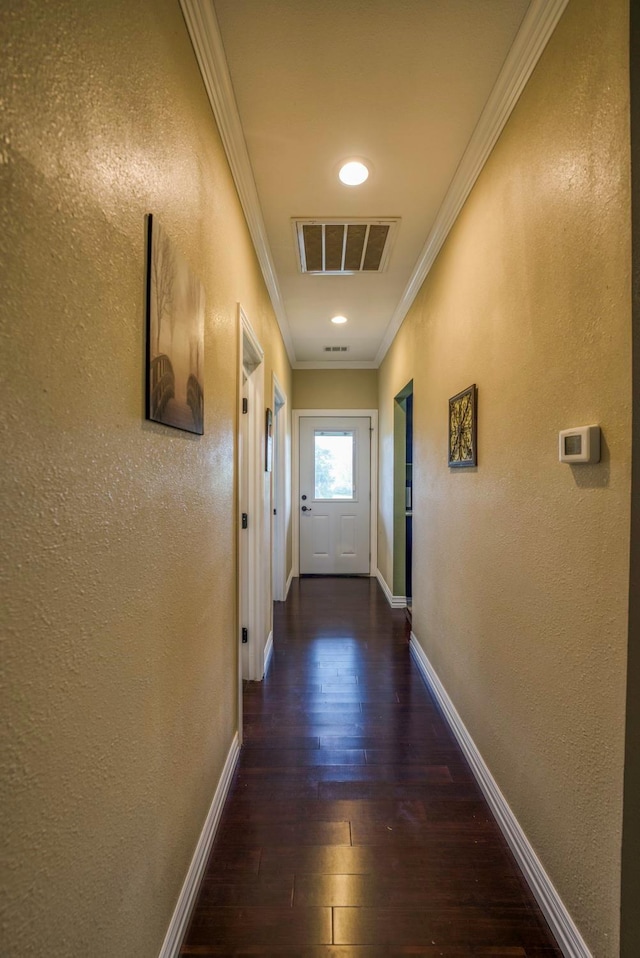 corridor with dark hardwood / wood-style flooring and ornamental molding