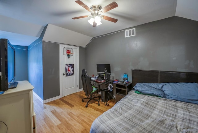 bedroom with ceiling fan, hardwood / wood-style floors, and vaulted ceiling