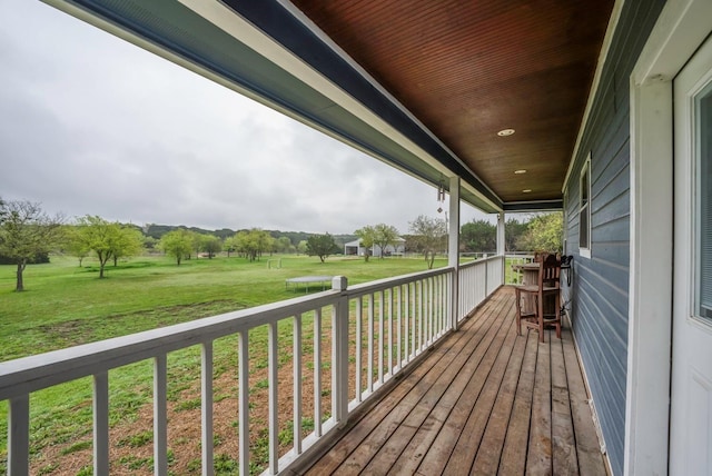 wooden deck featuring a lawn and covered porch