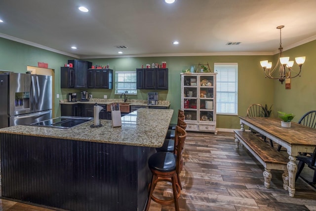 kitchen with pendant lighting, an inviting chandelier, stainless steel refrigerator with ice dispenser, dark hardwood / wood-style floors, and stovetop