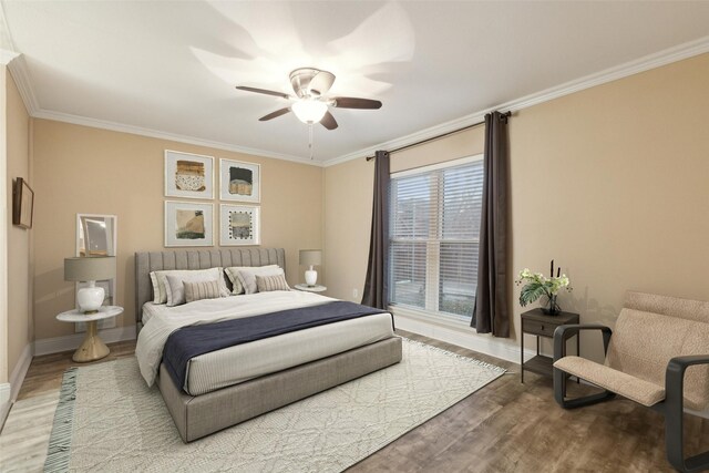 bedroom with ceiling fan, hardwood / wood-style floors, and ornamental molding