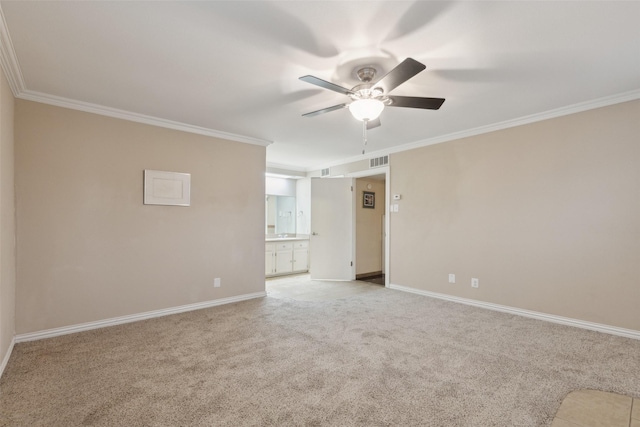 spare room featuring ceiling fan, crown molding, and light carpet