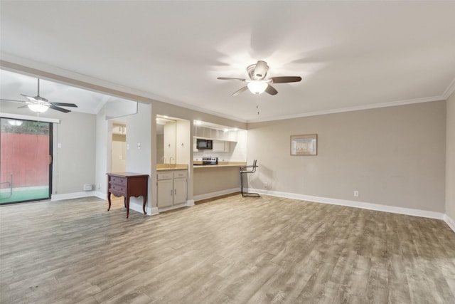 unfurnished living room with ceiling fan, sink, crown molding, vaulted ceiling, and light wood-type flooring