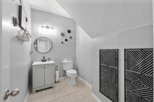 bathroom with tile patterned flooring, vanity, and toilet