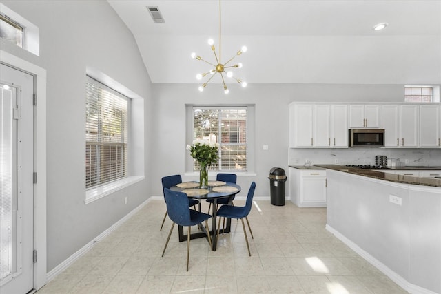 dining space featuring a chandelier and vaulted ceiling