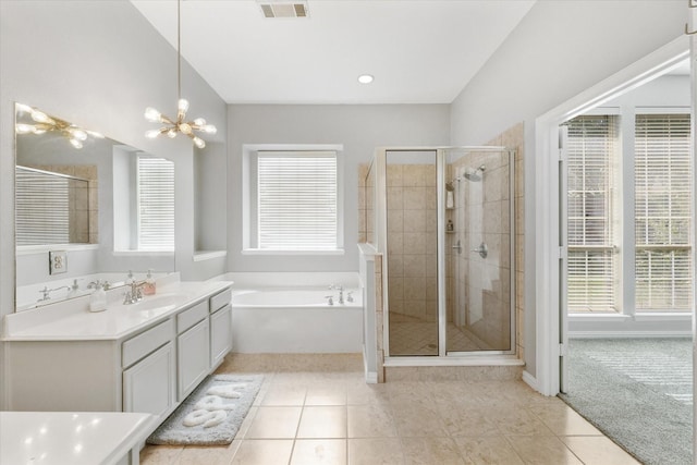 bathroom with tile patterned flooring, vanity, an inviting chandelier, and independent shower and bath