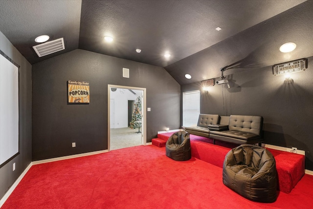 home theater with carpet flooring, a textured ceiling, and vaulted ceiling