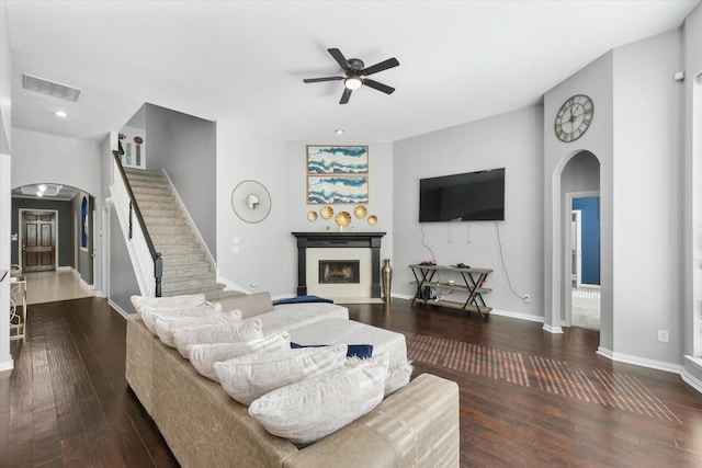 living room featuring ceiling fan and dark wood-type flooring