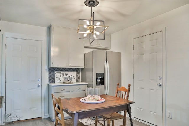 dining space featuring a notable chandelier and light wood-type flooring