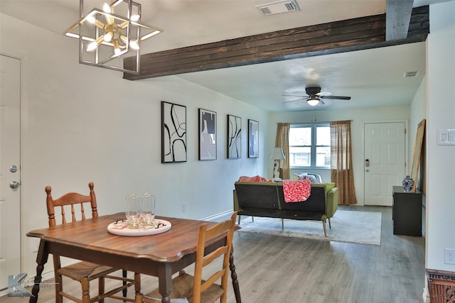 dining room featuring hardwood / wood-style floors, ceiling fan with notable chandelier, and beam ceiling