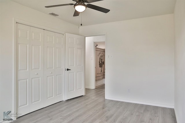 unfurnished bedroom with ceiling fan, light wood-type flooring, and a closet