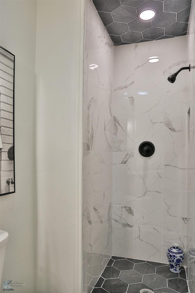 bathroom featuring toilet and tiled shower