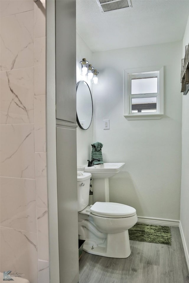 bathroom with hardwood / wood-style floors and toilet