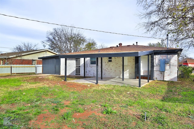 back of property with a patio area and a lawn