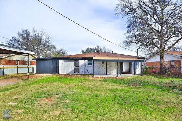 rear view of house with a patio and a lawn