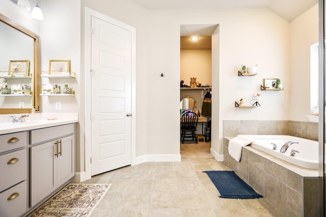 bathroom with vanity, tiled bath, tile patterned floors, and lofted ceiling