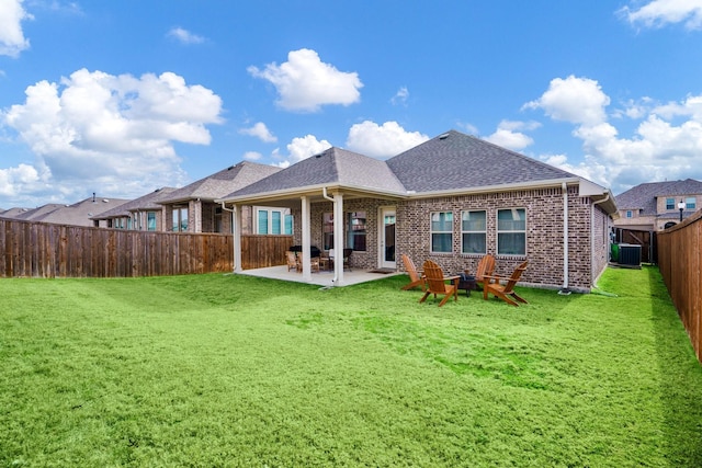 rear view of property featuring central AC, a patio area, and a lawn