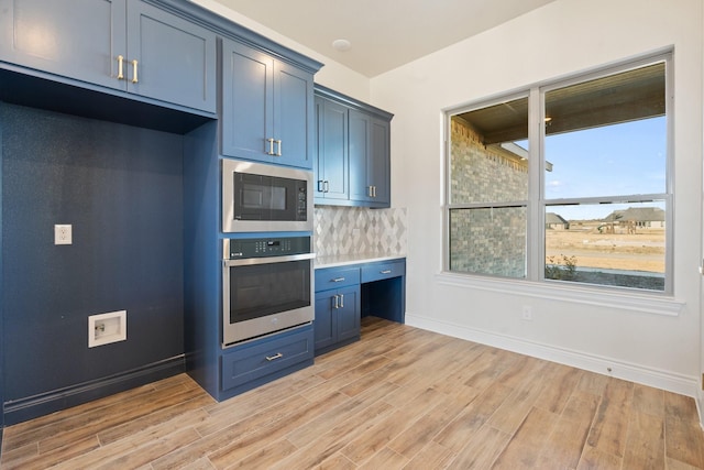 kitchen with blue cabinets, black microwave, oven, backsplash, and light hardwood / wood-style flooring