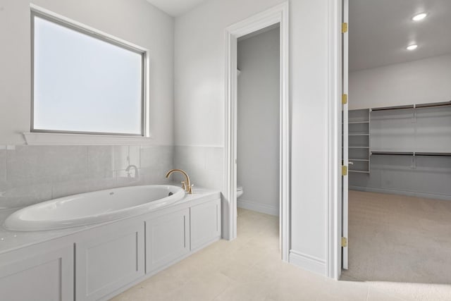 412 Collum, Azle, TX 76020 - bathroom with toilet, a bath, a spacious closet, and baseboards